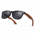Sunglasses with black frames and wooden arms on a white background