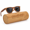 Wooden sunglasses with a cylindrical wooden case on a white background, branded 'cloudfield'.