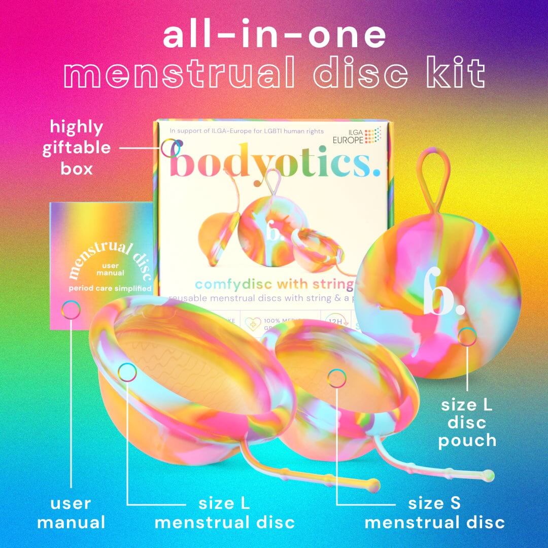 Bodyotics Comfydisc Rainbow Edition reusable menstrual disc kit with two silicone discs, string pull-off, carrying pouch, and user manual on rainbow background
