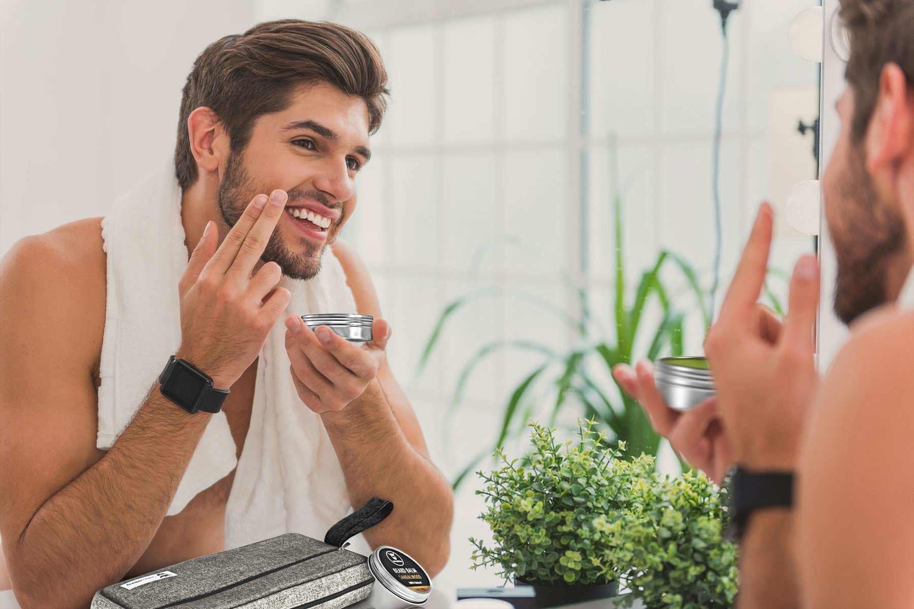 Man using beard grooming kit in front of mirror with toiletries and plants.