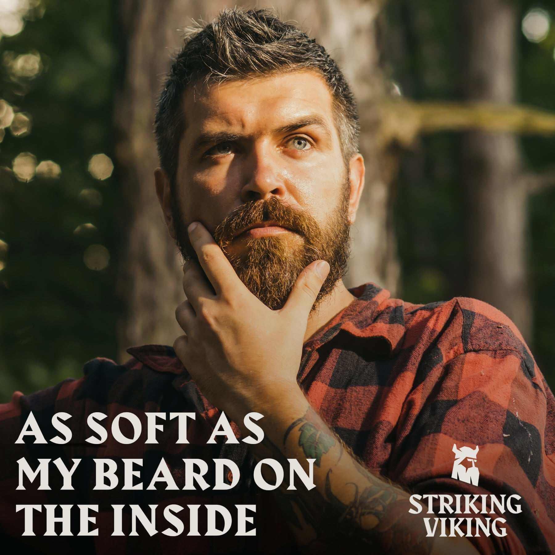 Man stroking beard outdoors with text "As Soft As My Beard On The Inside" promoting Striking Viking Beard Oil Unscented.